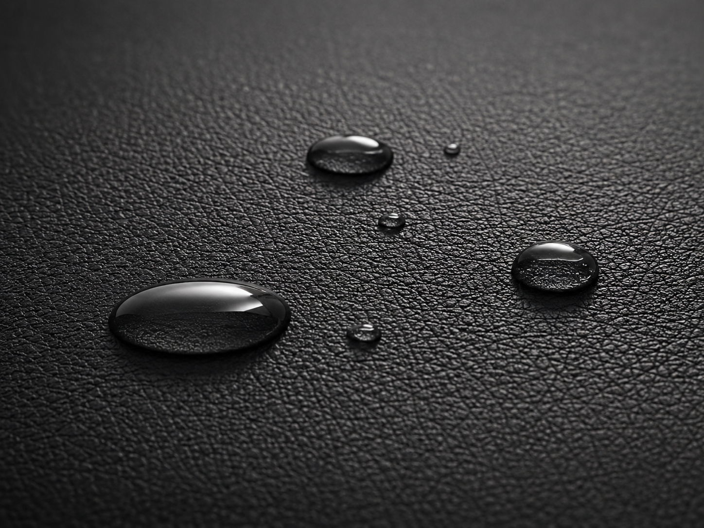 Water droplets on black synthetic leather easy clean surface