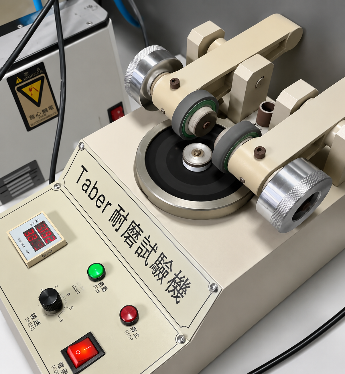Two-arm Taber abrasion tester used to evaluate the wear resistance of a Semi PU leather sample